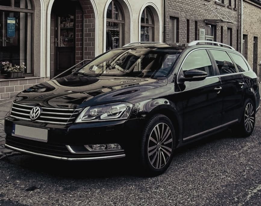 Svart Volkswagen Passat stasjonsvogn foran en murbygning